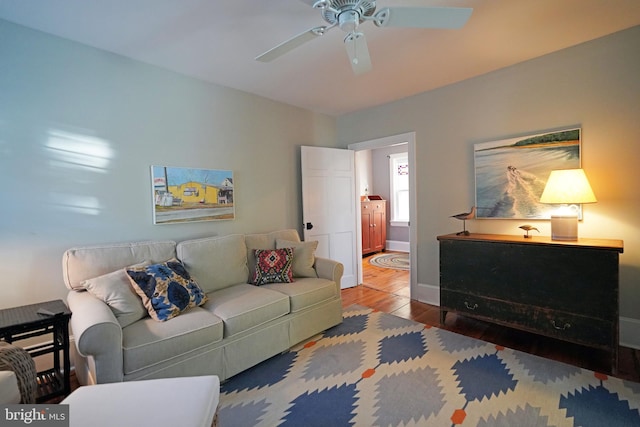 living room with baseboards, ceiling fan, and wood finished floors