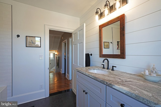 bathroom featuring vanity and wooden walls