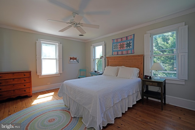 bedroom with crown molding, baseboards, multiple windows, and hardwood / wood-style flooring