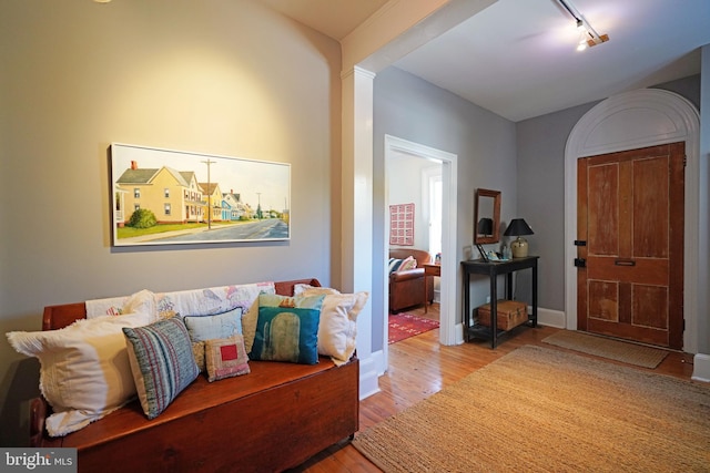 foyer entrance featuring baseboards, rail lighting, and wood finished floors