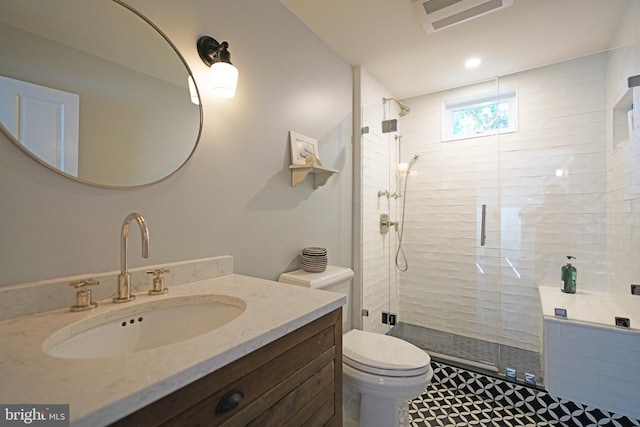 full bathroom featuring vanity, toilet, visible vents, and a stall shower