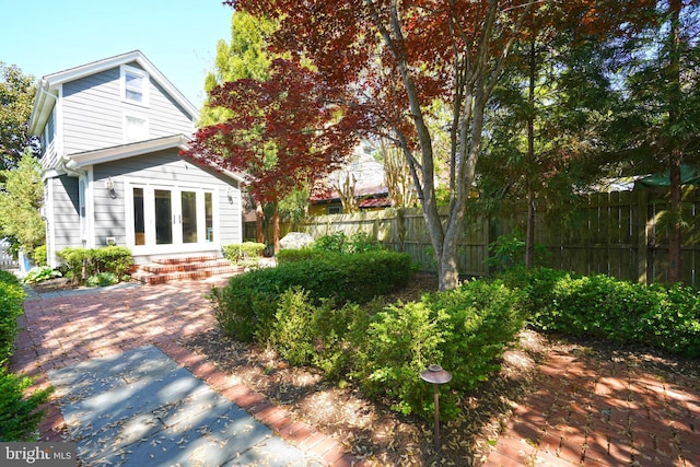 rear view of property featuring fence and french doors