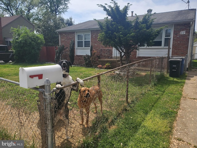 view of front of home with brick siding, a front yard, and fence private yard