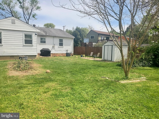 view of yard featuring a storage unit, an outdoor structure, central AC, and fence