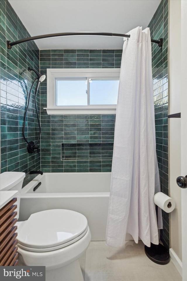 bathroom featuring toilet and shower / bath combination with curtain
