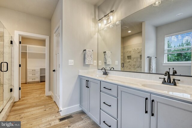 19103 Windsor, Drayden, MD 20630 - bathroom with double vanity, a stall shower, wood finished floors, and a sink