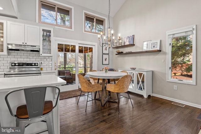 dining area featuring a wealth of natural light, visible vents, dark wood-style flooring, and a chandelier