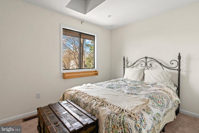 carpeted bedroom featuring baseboards and visible vents