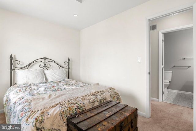bedroom with baseboards, carpet flooring, visible vents, and ensuite bath