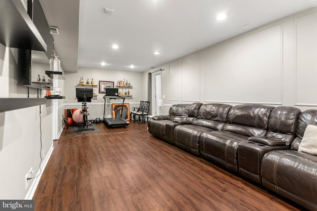 living area with a dry bar, dark wood-style floors, a decorative wall, and recessed lighting