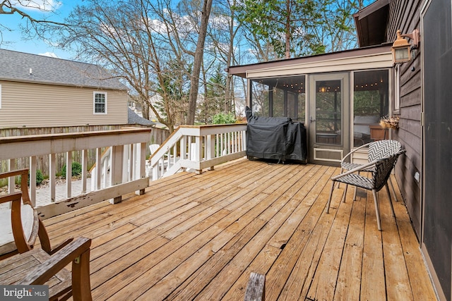 wooden deck featuring grilling area and a sunroom