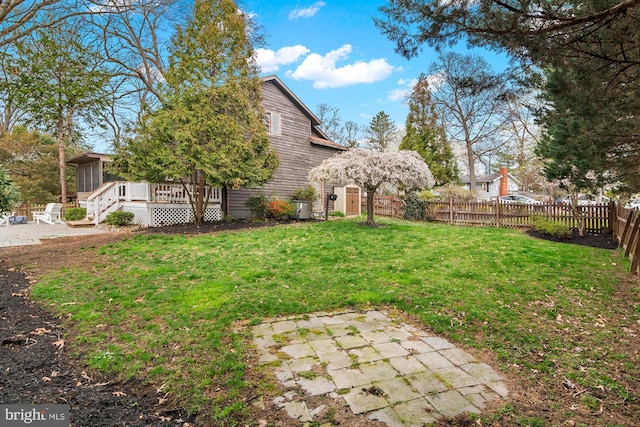 view of yard featuring a fenced backyard, a sunroom, a deck, and a patio area