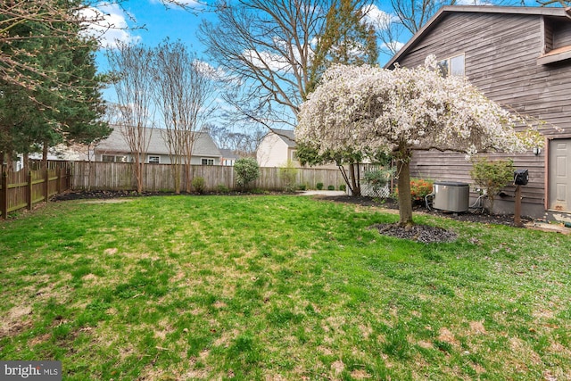 view of yard featuring a fenced backyard and central AC