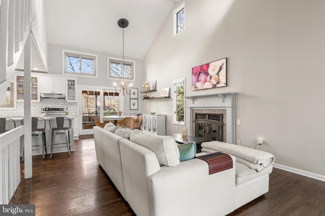 living area with dark wood finished floors, a glass covered fireplace, and a wealth of natural light