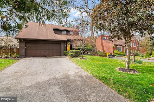 mid-century inspired home with aphalt driveway, fence, a chimney, a garage, and a front yard