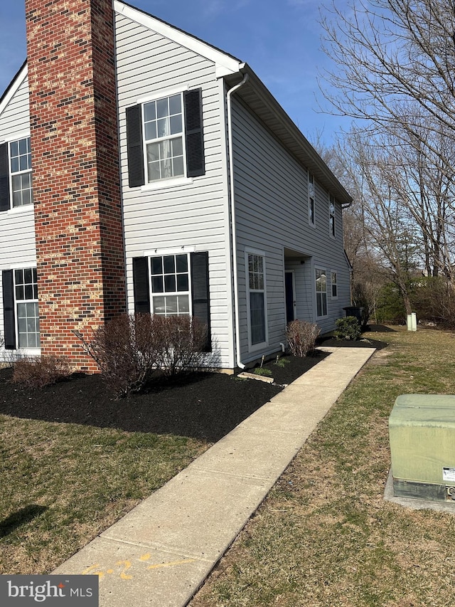 view of home's exterior with a yard and a chimney