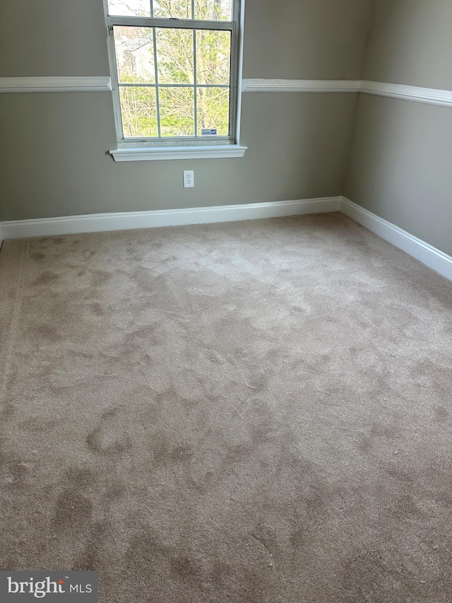 unfurnished room with baseboards and carpet