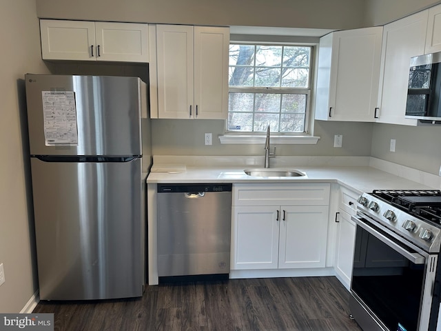 kitchen featuring a sink, dark wood finished floors, stainless steel appliances, white cabinets, and light countertops