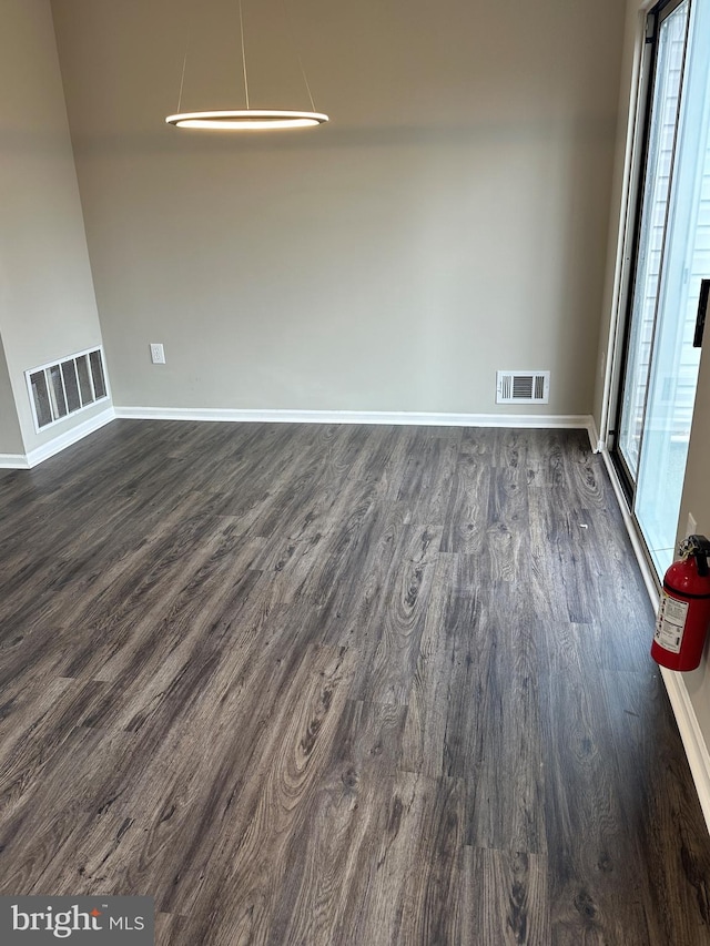 unfurnished room with dark wood finished floors, baseboards, and visible vents