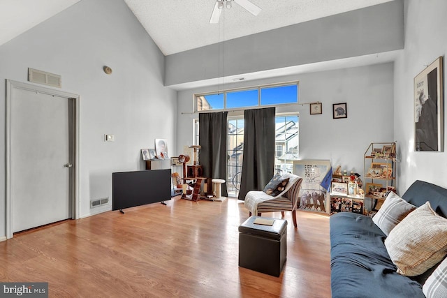 living room with visible vents, high vaulted ceiling, wood finished floors, and a ceiling fan