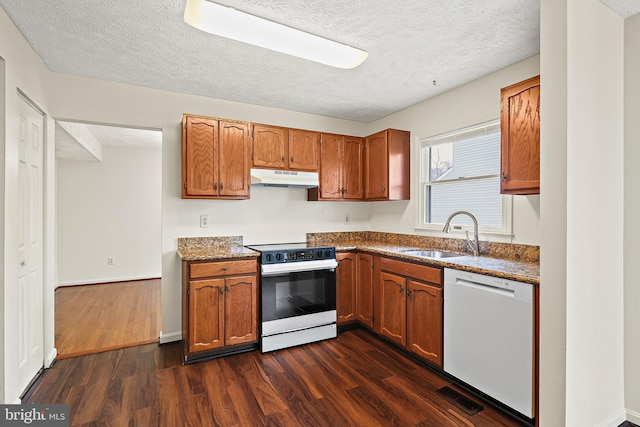 kitchen with a sink, electric range oven, dishwasher, under cabinet range hood, and dark wood-style flooring