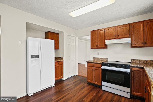 kitchen with white appliances, under cabinet range hood, a textured ceiling, dark wood-style floors, and brown cabinets