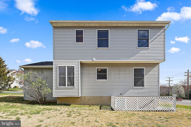 rear view of house featuring a lawn