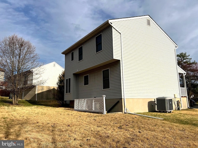 rear view of property with a lawn and cooling unit