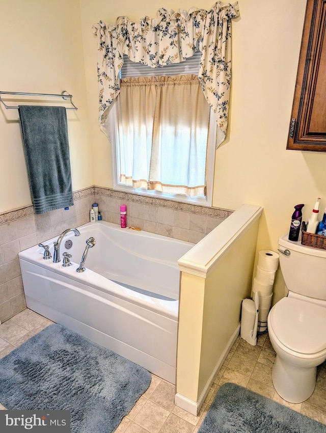 full bathroom featuring tile patterned floors, toilet, and a garden tub