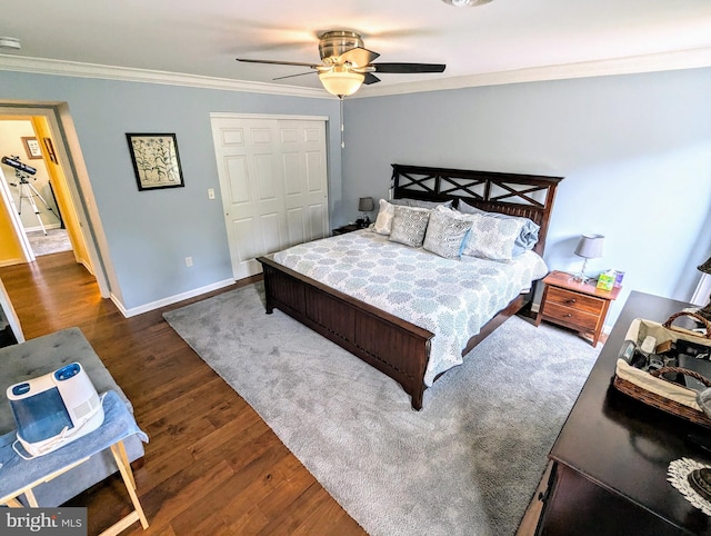 bedroom featuring wood finished floors, baseboards, ceiling fan, a closet, and crown molding