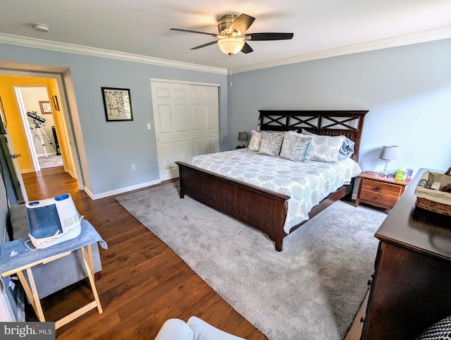 bedroom featuring a closet, baseboards, wood finished floors, and ornamental molding