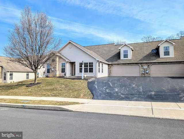 view of front facade featuring a front lawn, stone siding, roof with shingles, and aphalt driveway