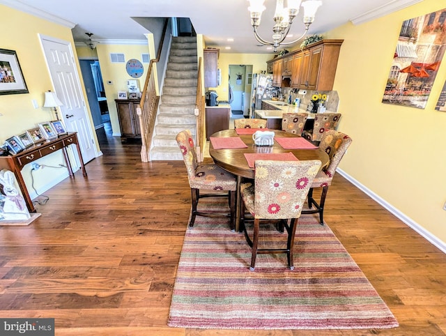 dining space featuring dark wood-type flooring, ornamental molding, baseboards, a chandelier, and stairs