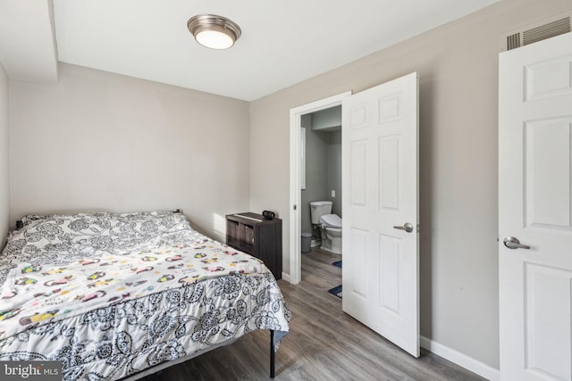 bedroom featuring wood finished floors, visible vents, and baseboards