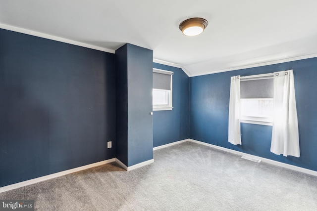 unfurnished room featuring baseboards, lofted ceiling, carpet floors, and visible vents