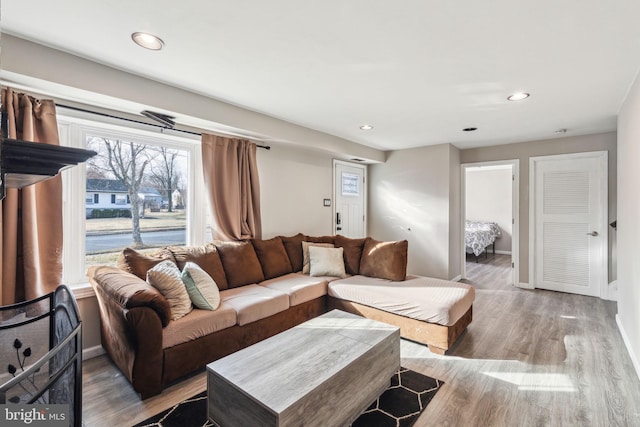 living area featuring recessed lighting, baseboards, and wood finished floors