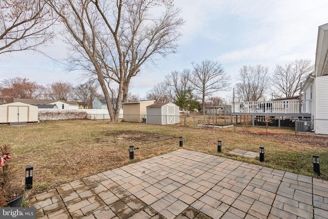 view of patio featuring a fenced backyard, central AC, a storage unit, and an outdoor structure