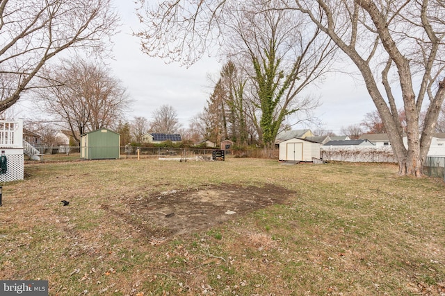 view of yard featuring an outbuilding, a storage shed, and a fenced backyard