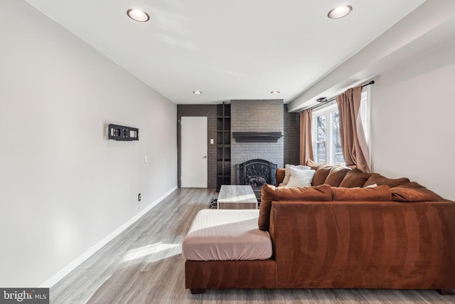 living room with recessed lighting, baseboards, wood finished floors, and a fireplace