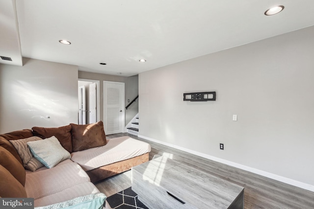 living area featuring recessed lighting, baseboards, wood finished floors, and stairs