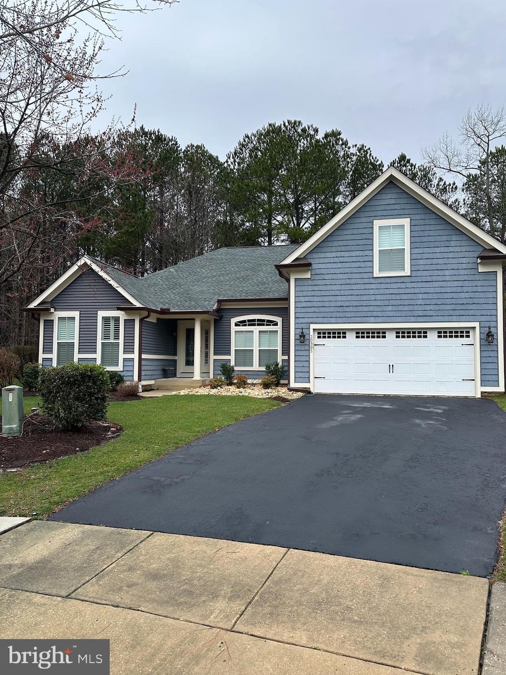 view of front of home featuring a garage, a front yard, and driveway