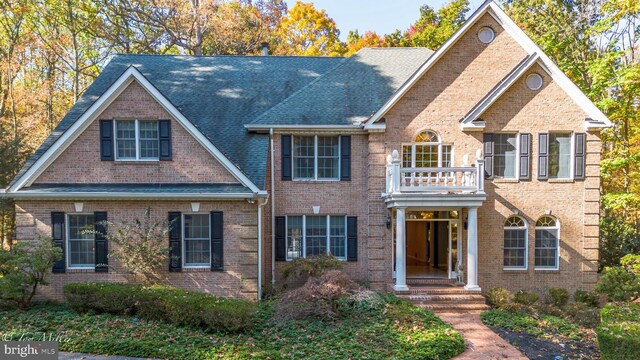 view of front of property featuring a balcony and brick siding