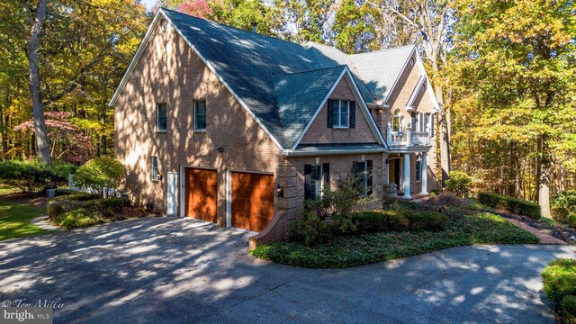 view of front of property with brick siding, a balcony, concrete driveway, and an attached garage