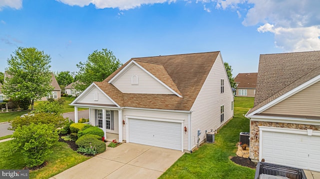 traditional home featuring a front yard, driveway, roof with shingles, and cooling unit