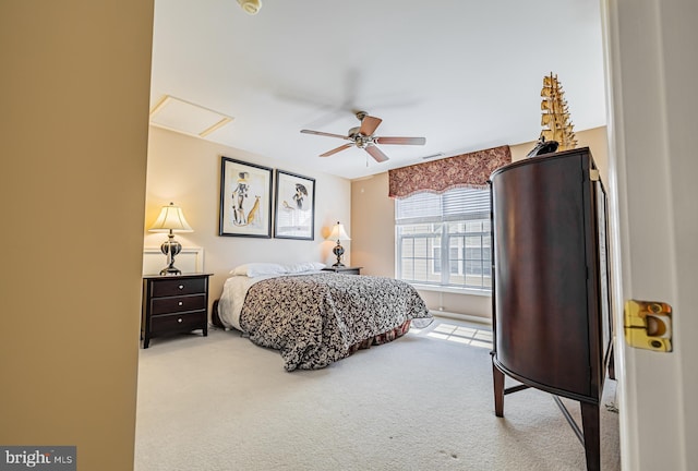 carpeted bedroom with attic access and ceiling fan