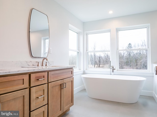 full bathroom with a soaking tub and vanity