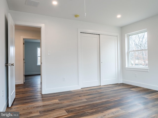 unfurnished bedroom featuring visible vents, dark wood-type flooring, baseboards, recessed lighting, and a closet