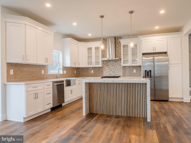 kitchen with light countertops, appliances with stainless steel finishes, white cabinets, wall chimney exhaust hood, and dark wood-style flooring