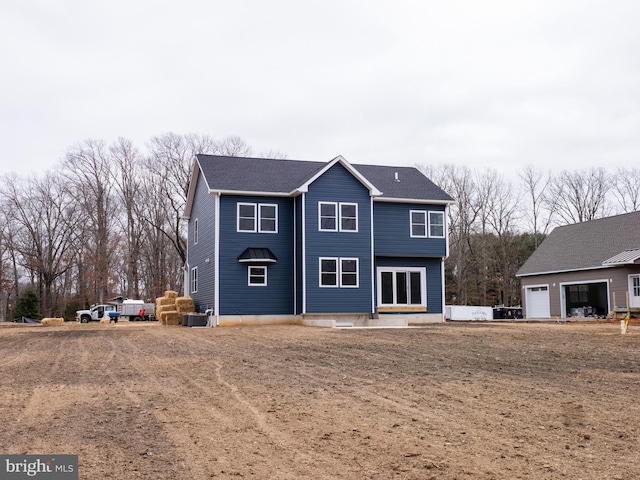 view of front of home with central air condition unit and a garage