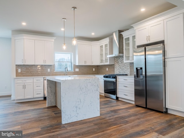 kitchen featuring a sink, stainless steel appliances, dark wood-type flooring, white cabinetry, and wall chimney exhaust hood